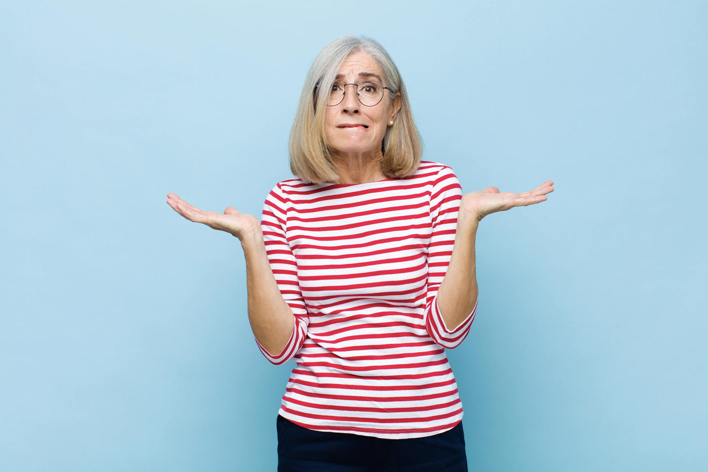 Kvinde står med armene og ser spørgende ud