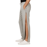 Graue Jogginghose mit offenem Seitenreißverschluss, der das Bein zeigt, seitlich an einer Person